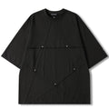 A black oversized short-sleeve t-shirt with diagonal seam details and small silver snap buttons, shown flat on a white background. The brand name 'VENDOUT' is visible on the inner neck label.