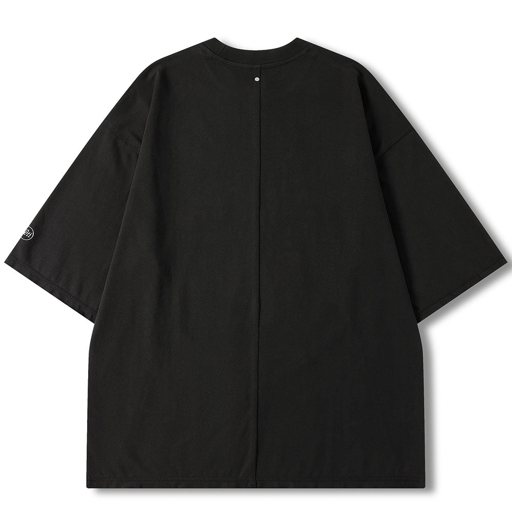 A black oversized short-sleeve t-shirt with diagonal seam details and small silver snap buttons, shown flat on a white background. The brand name 'VENDOUT' is visible on the inner neck label.