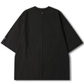 A black short-sleeve t-shirt with a crew neck, laid flat against a white background. It features a small white circular logo on the left sleeve and a central vertical seam running from the collar to the hem.