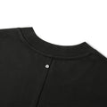 Close-up of a black crewneck sweatshirt showing the ribbed collar and a silver metal snap button closure on a white background.